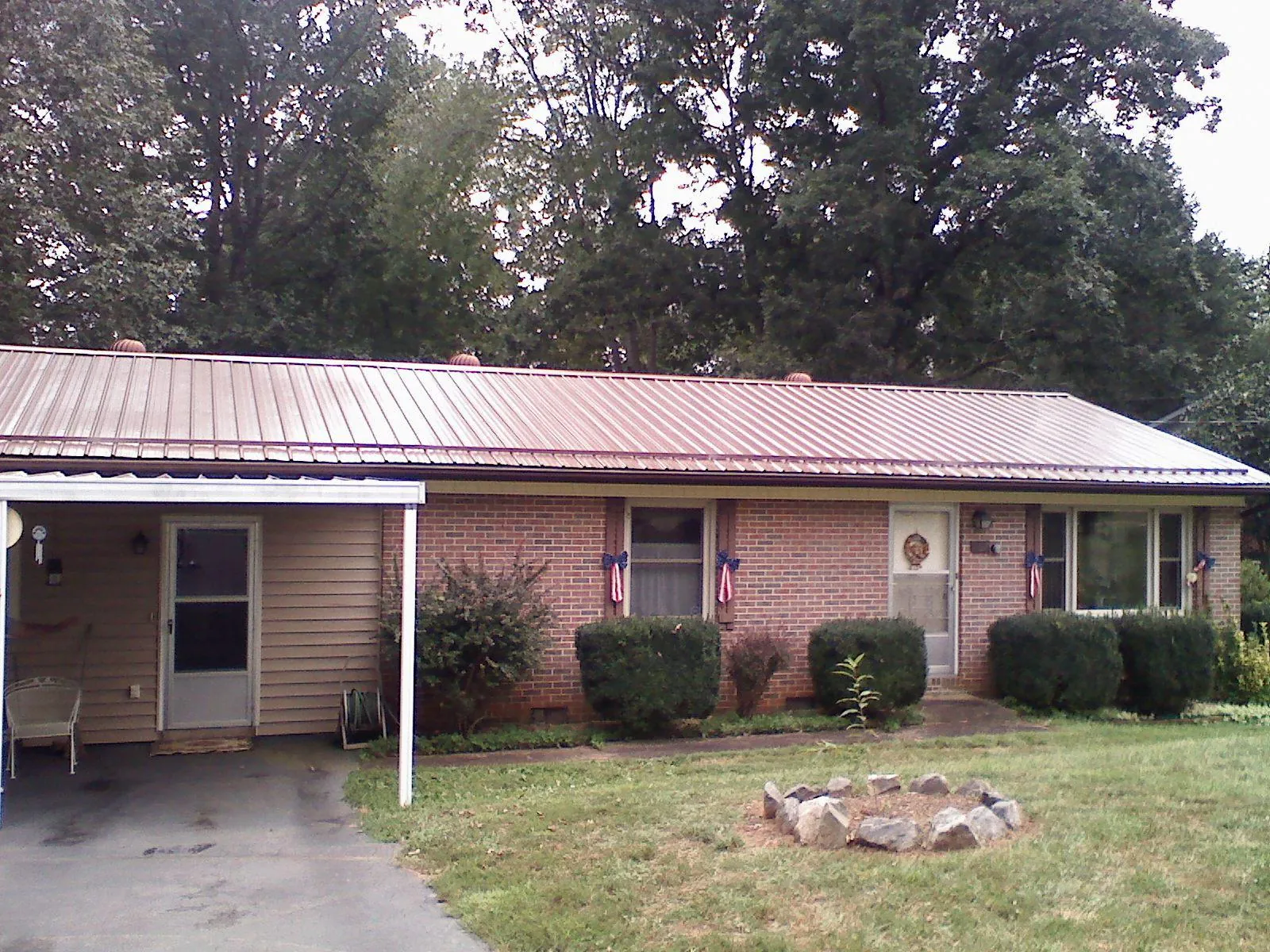 Bronze metal roof and carport on a brick ranch home — Roof Repair work by our crew in Aldie